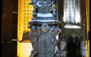  Rzeźba św. Jana Nepomucena. W tle dwukondygnacyjny kościół św. Krzyża i św. Bartłomieja